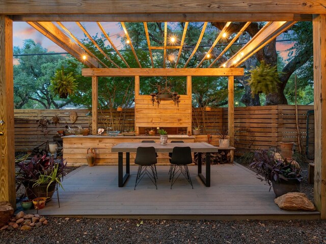 wooden terrace with a fenced backyard, a pergola, and outdoor dining area