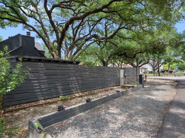 view of side of home featuring fence and a chimney