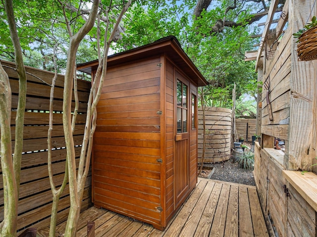 view of outbuilding with fence and an outbuilding