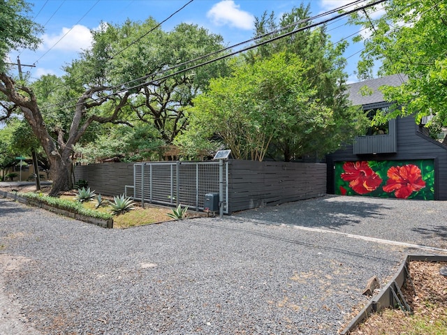 view of property exterior featuring fence and a shingled roof