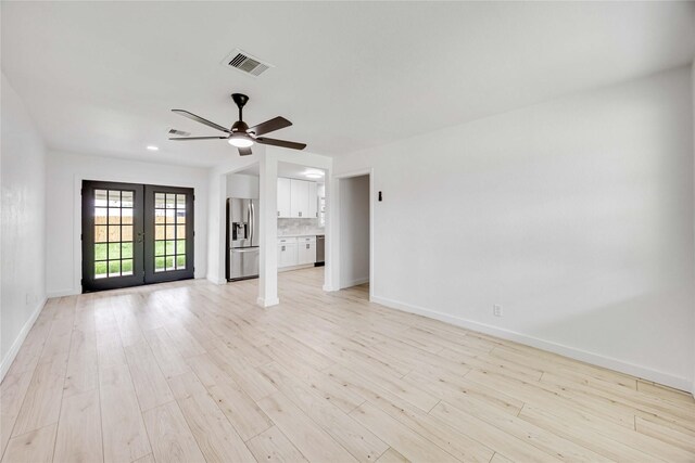 unfurnished living room featuring french doors, baseboards, ceiling fan, and light wood-style floors