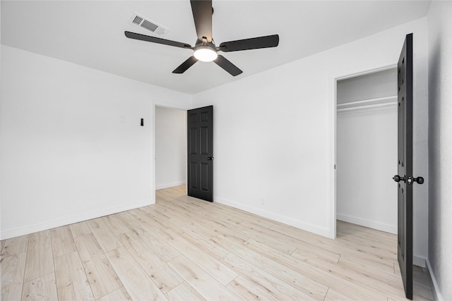 unfurnished bedroom featuring light wood-style floors, a closet, baseboards, and a ceiling fan