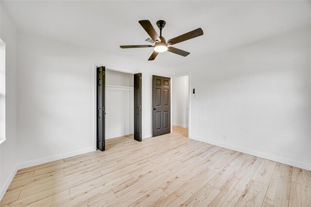 unfurnished bedroom with light wood-style flooring, baseboards, a closet, and a ceiling fan