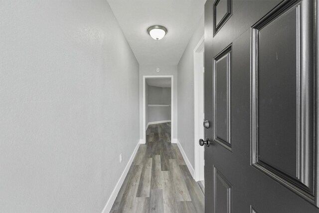 hall with wood finished floors and baseboards