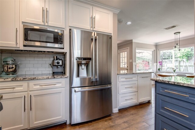 6031 Mcknight St, Houston, TX 77035 - kitchen featuring stainless steel appliances, ornamental molding, decorative backsplash, white cabinets, and dark wood finished floors