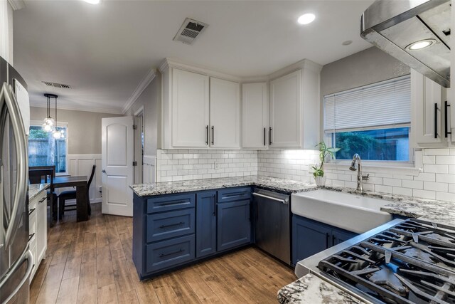 6031 Mcknight St, Houston, TX 77035 - kitchen with blue cabinetry, stainless steel appliances, white cabinets, crown molding, and a sink