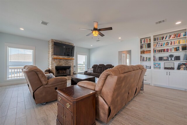 living room with light wood-type flooring, a ceiling fan, a fireplace, and recessed lighting