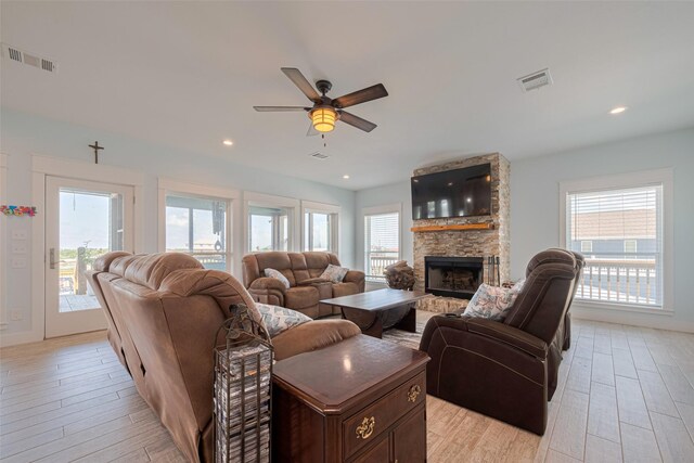 living room featuring a ceiling fan, light wood-style floors, a fireplace, and recessed lighting
