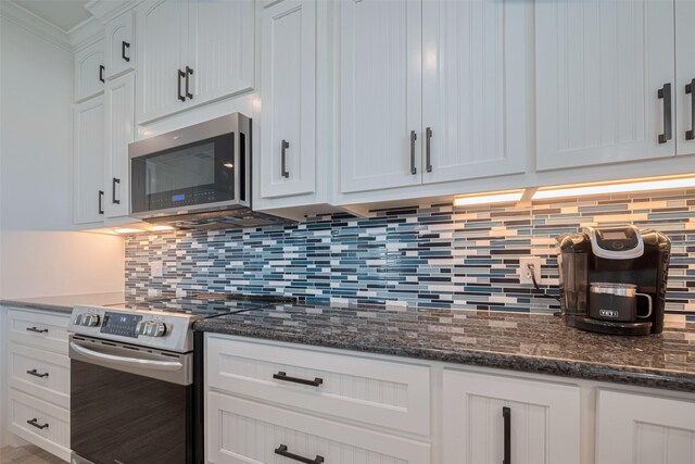 kitchen with stainless steel appliances, tasteful backsplash, white cabinets, and ornamental molding