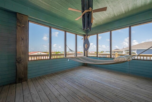 unfurnished sunroom with a ceiling fan
