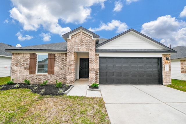 ranch-style home with brick siding, an attached garage, concrete driveway, a shingled roof, and a front lawn