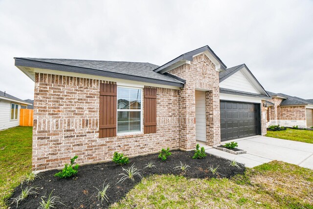 ranch-style home with brick siding, an attached garage, concrete driveway, and fence