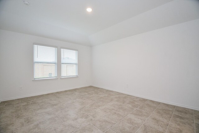 spare room featuring recessed lighting and baseboards