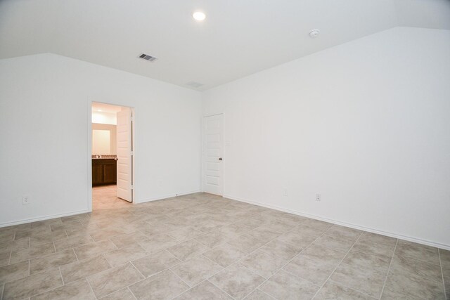 spare room with vaulted ceiling