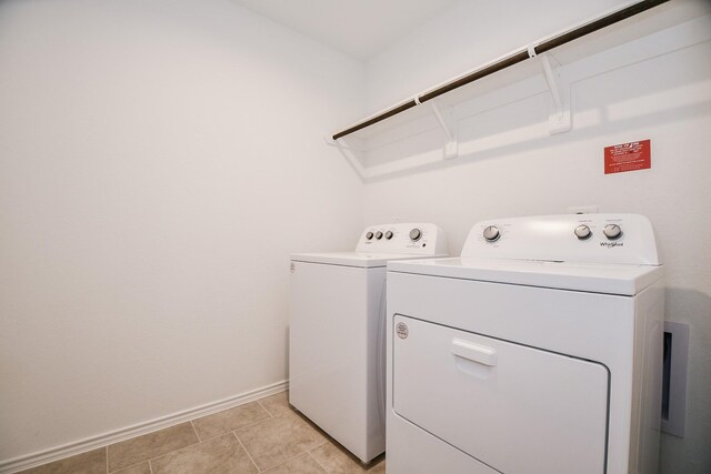 washroom with washing machine and dryer and baseboards
