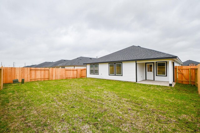 rear view of house with a patio and roof with shingles