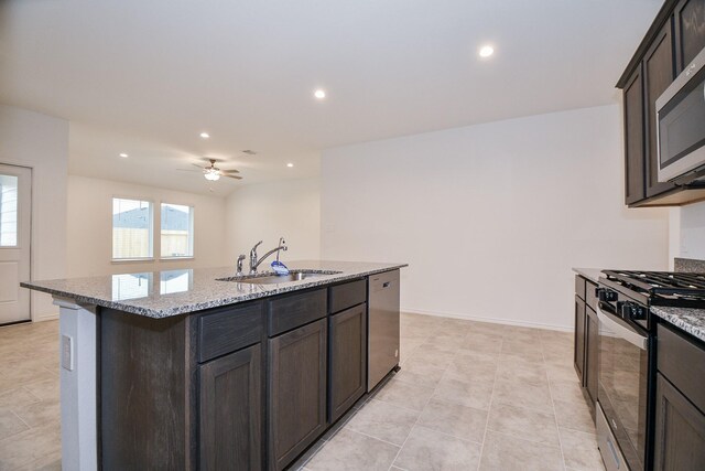 kitchen with a sink, stainless steel appliances, light stone counters, recessed lighting, and a ceiling fan