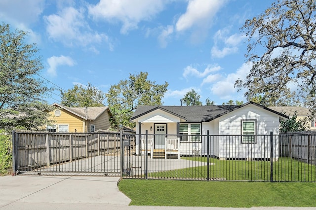 view of front facade featuring driveway, a gate, and roof with shingles