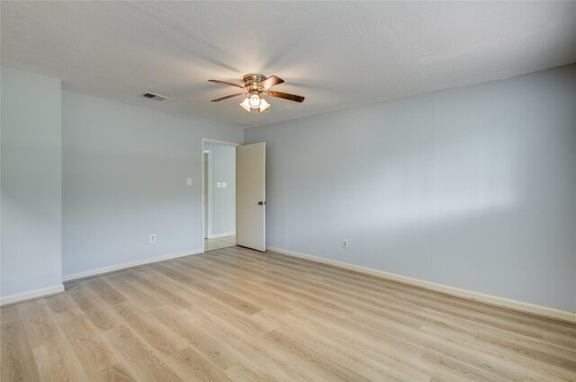 unfurnished room featuring ceiling fan, light wood finished floors, and baseboards