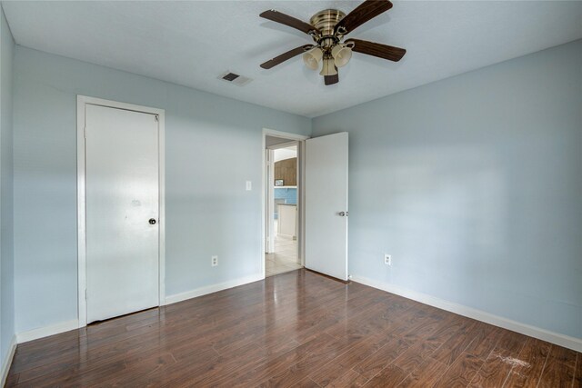unfurnished bedroom with wood finished floors, baseboards, and a ceiling fan
