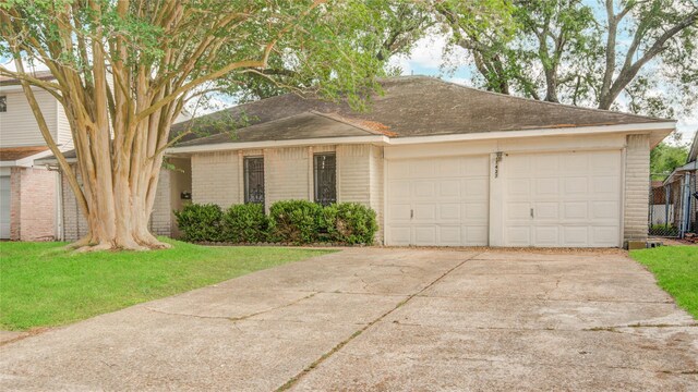 ranch-style home with a garage, driveway, brick siding, roof with shingles, and a front lawn
