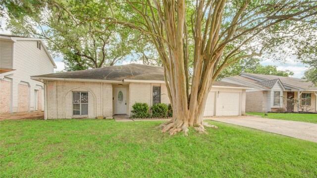 view of front of home with an attached garage, brick siding, driveway, and a front lawn