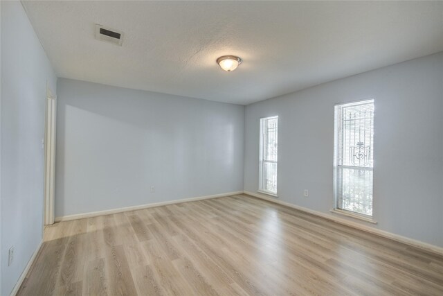 empty room with light wood finished floors and baseboards