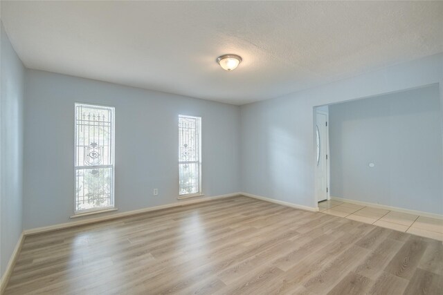 spare room with light wood finished floors and baseboards