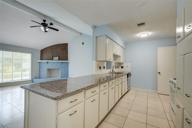 kitchen with dishwasher, a peninsula, a sink, and light tile patterned floors