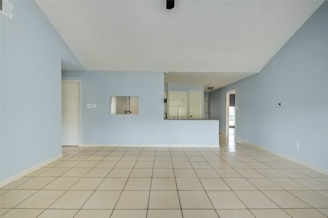 unfurnished living room with light tile patterned flooring and baseboards