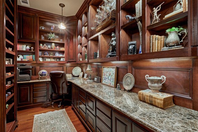 wine cellar with built in desk and light wood-style flooring
