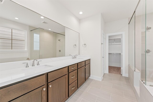 full bathroom featuring a shower stall, a walk in closet, double vanity, tile patterned flooring, and recessed lighting