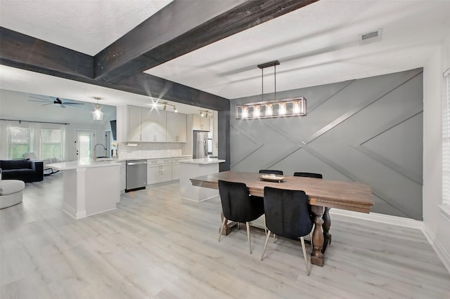 dining area featuring light wood finished floors, baseboards, beamed ceiling, and a ceiling fan