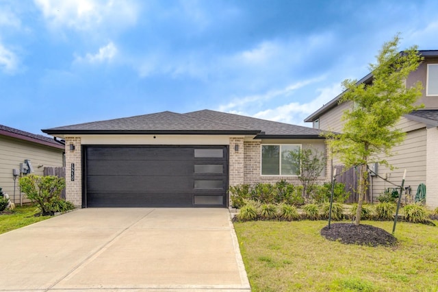 view of front of property with an attached garage, brick siding, driveway, a front yard, and roof with shingles