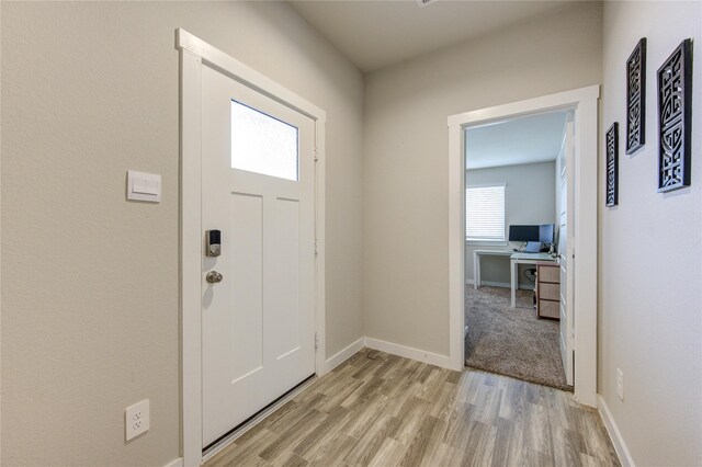 foyer with light wood-type flooring and baseboards
