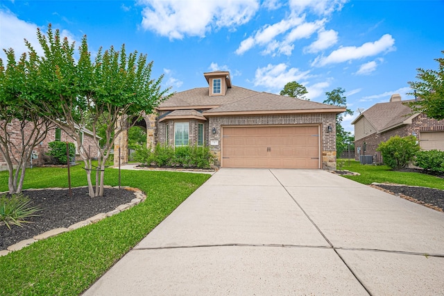 view of front of property featuring a front yard, an attached garage, concrete driveway, and cooling unit