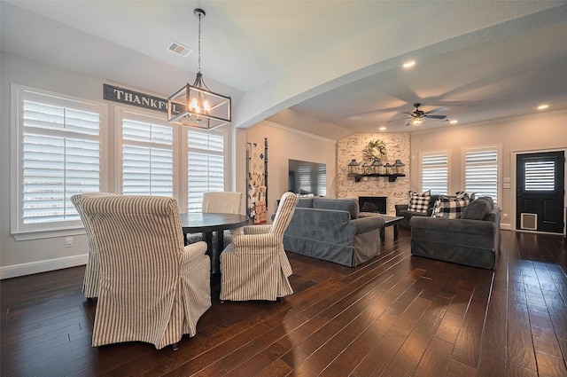 dining room featuring ceiling fan, a chandelier, dark wood-style floors, baseboards, and arched walkways