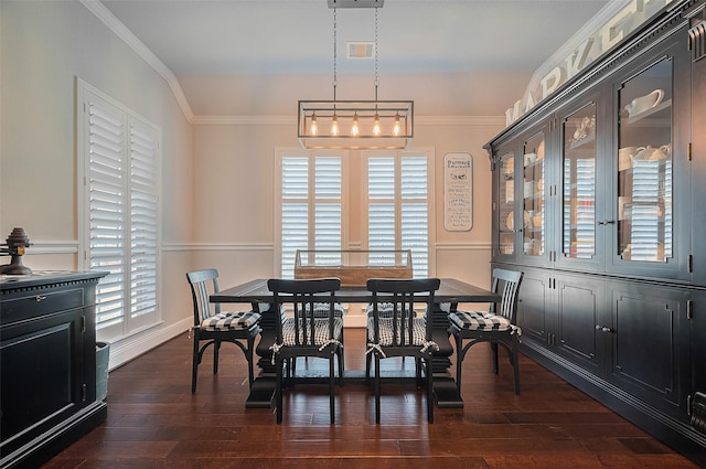 dining area with ornamental molding and dark wood-type flooring