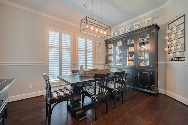 dining area with ornamental molding, dark wood-type flooring, baseboards, and a chandelier