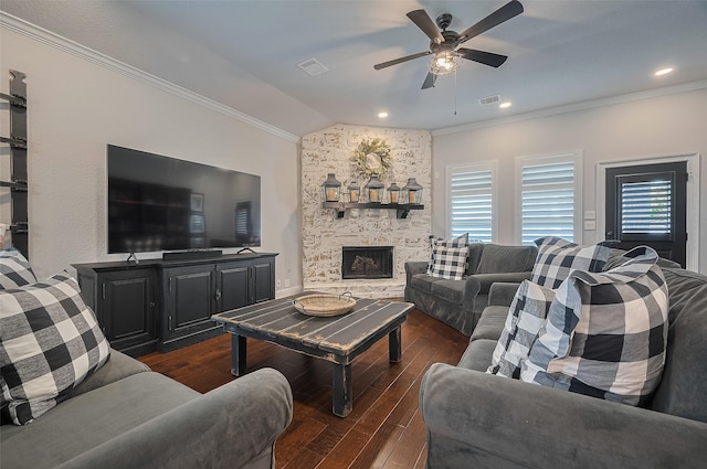 living room with ornamental molding, vaulted ceiling, wood-type flooring, a ceiling fan, and a fireplace