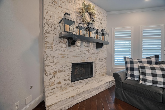 living room featuring wood finished floors, ornamental molding, and a fireplace
