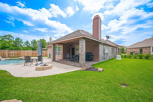 rear view of property with a chimney, a ceiling fan, an outdoor fire pit, and a patio