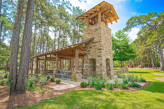 view of home's community featuring a lawn and a patio