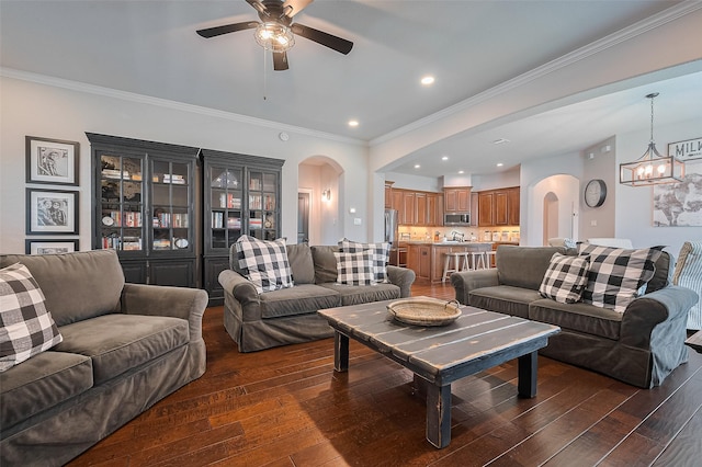 living room with arched walkways, dark wood finished floors, ceiling fan, a chandelier, and recessed lighting