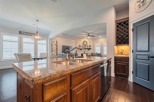 kitchen featuring open floor plan, a sink, an island with sink, stainless steel dishwasher, and ceiling fan