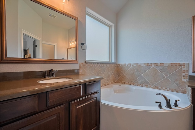 bathroom featuring vanity and a bath