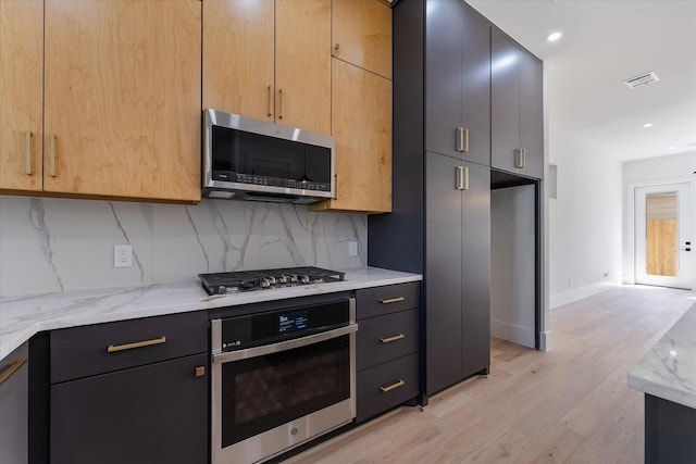 3912 Tulane St, Houston, TX 77018 - kitchen with stainless steel appliances, backsplash, light wood-style flooring, light stone countertops, and baseboards