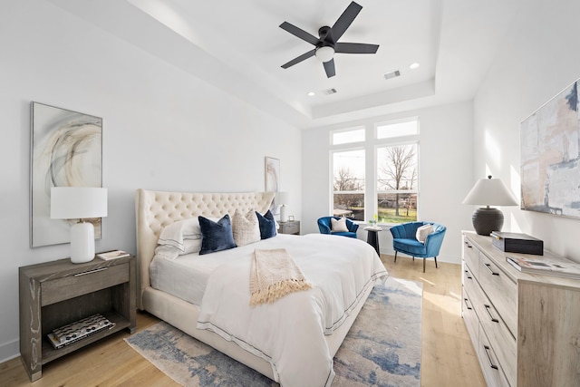 431 Neyland St, Houston, TX 77022 - bedroom with light wood-type flooring, a tray ceiling, a ceiling fan, and recessed lighting