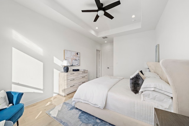 431 Neyland St, Houston, TX 77022 - bedroom with light wood-type flooring, recessed lighting, a raised ceiling, a ceiling fan, and baseboards