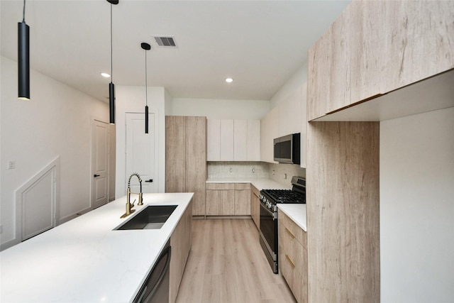 431 Neyland St, Houston, TX 77022 - kitchen featuring modern cabinets, appliances with stainless steel finishes, light brown cabinets, light wood finished floors, and tasteful backsplash